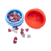 Open Rocket Wobbler Treat Dispenser filled with small heart-shaped dog treats for interactive feeding.